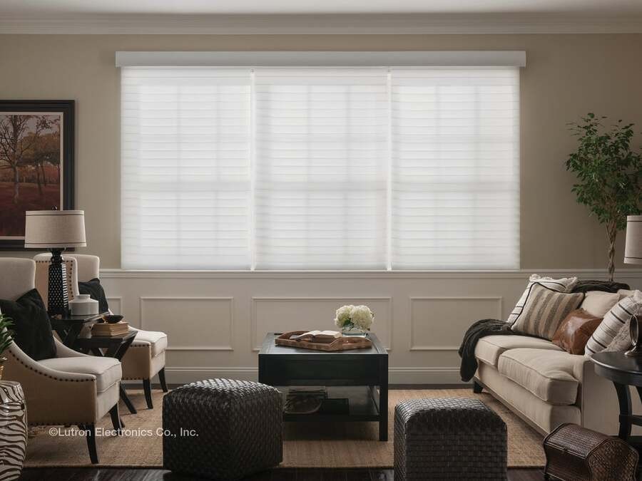 An elegant living room with Lutron motorized shades covering a large window.