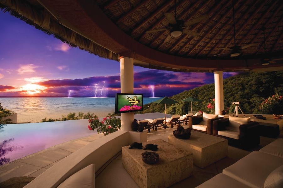 An oceanfront property with a large backyard patio and a Séura outdoor 